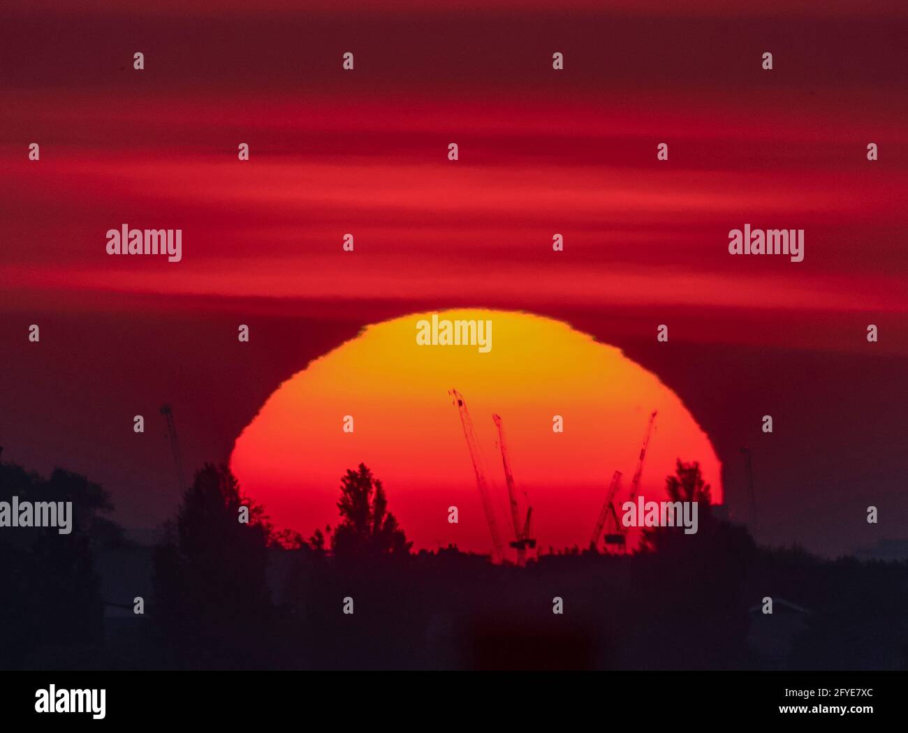 Wimbledon, Londres, Royaume-Uni. 28 mai 2021. Soleil orange profond au-dessus de Londres avant le début de la matinée, le nuage se déploie au début d'une journée douce dans la capitale. La légère tache d'un groupe de taches solaires est visible dans le quadrant supérieur droit du disque solaire. Crédit : Malcolm Park/Alay Live News. Banque D'Images
