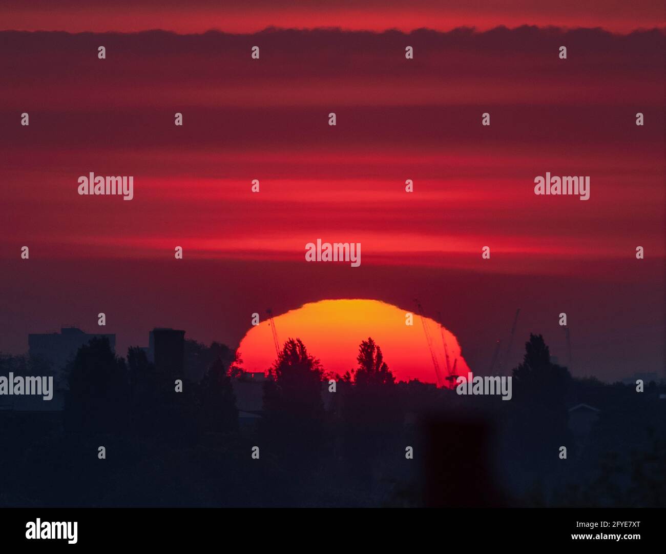 Wimbledon, Londres, Royaume-Uni. 28 mai 2021. Soleil orange profond au-dessus de Londres avant le début de la matinée, le nuage se déploie au début d'une journée douce dans la capitale. La légère tache d'un groupe de taches solaires est visible dans le quadrant supérieur droit du disque solaire. Crédit : Malcolm Park/Alay Live News. Banque D'Images