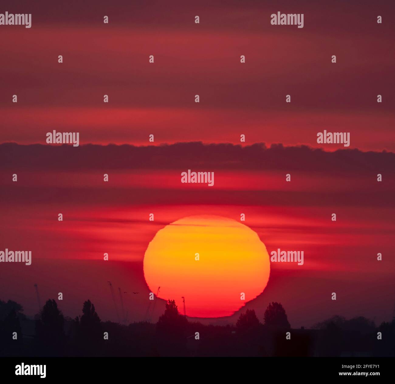 Wimbledon, Londres, Royaume-Uni. 28 mai 2021. Soleil orange profond au-dessus de Londres avant le début de la matinée, le nuage se déploie au début d'une journée douce dans la capitale. La légère tache d'un groupe de taches solaires est visible dans le quadrant supérieur droit du disque solaire. Crédit : Malcolm Park/Alay Live News. Banque D'Images