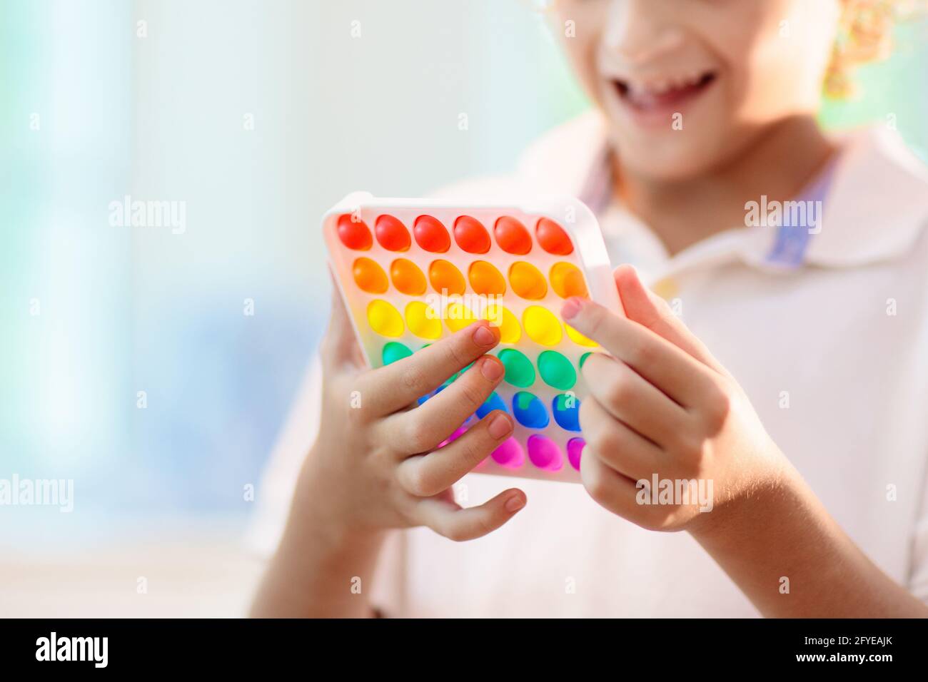 Les enfants jouent avec un jouet sensoriel pop IT. Soulagement du stress et de l'anxiété. Jeu de fidgeting de silicium tendance pour les enfants et les adultes stressés. Banque D'Images