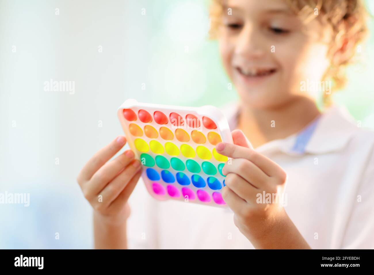 Les enfants jouent avec un jouet sensoriel pop IT. Soulagement du stress et de l'anxiété. Jeu de fidgeting de silicium tendance pour les enfants et les adultes stressés. Banque D'Images