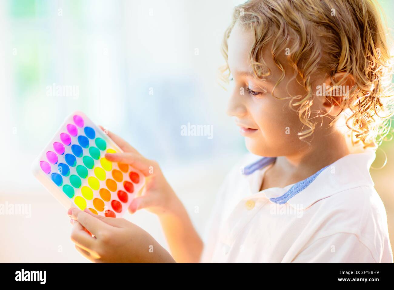 Les enfants jouent avec un jouet sensoriel pop IT. Soulagement du stress et de l'anxiété. Jeu de fidgeting de silicium tendance pour les enfants et les adultes stressés. Banque D'Images