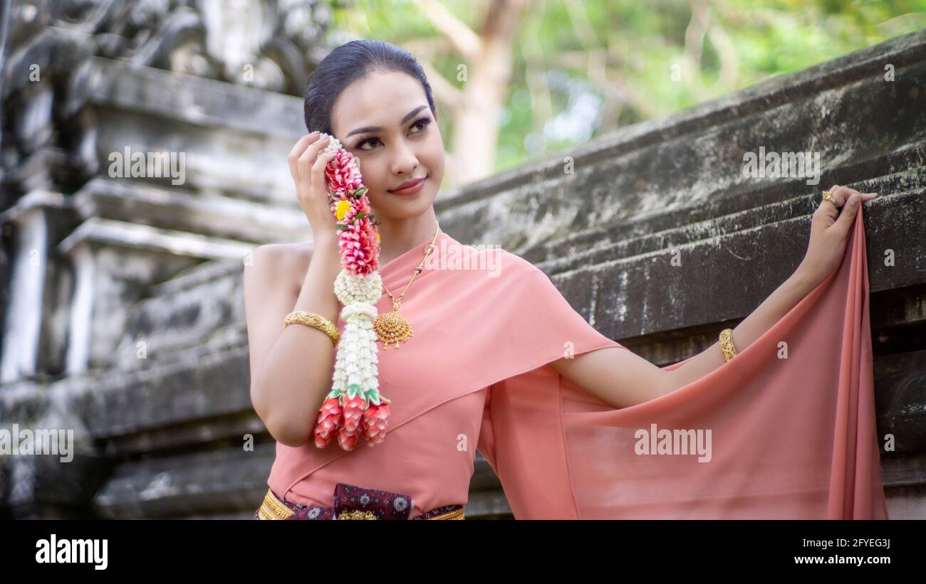 Belle femme, costume thaïlandais national, robe traditionnelle thaïlandaise, femme thaïlandaise, bonne humeur, Magnifique arrière-plan sourire - image avec bruit et grain Banque D'Images
