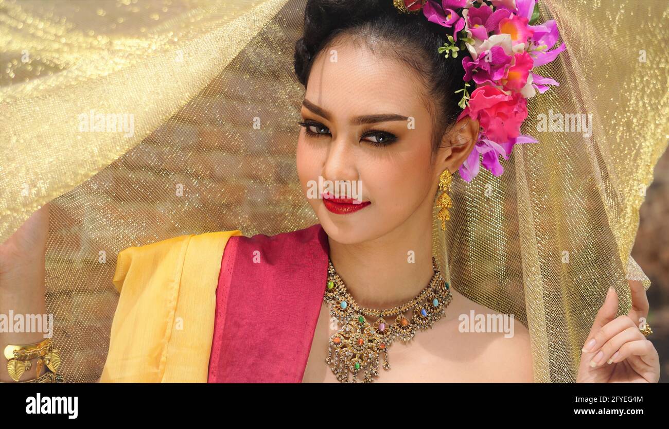 Belle femme, costume thaïlandais national, robe traditionnelle thaïlandaise, femme thaïlandaise, bonne humeur, Magnifique arrière-plan sourire - image avec bruit et grain Banque D'Images