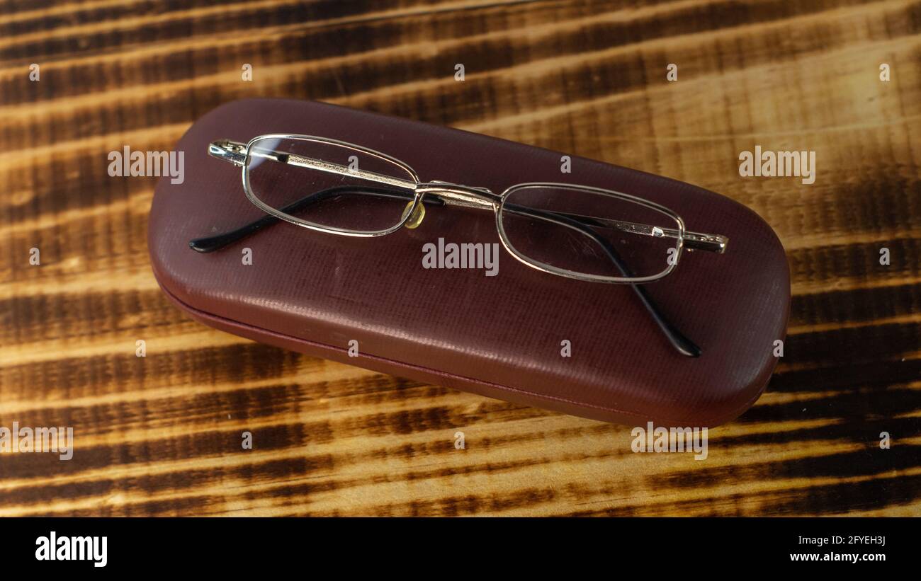 Photo des lunettes avec étui sur une base en bois sur fond blanc Photo  Stock - Alamy