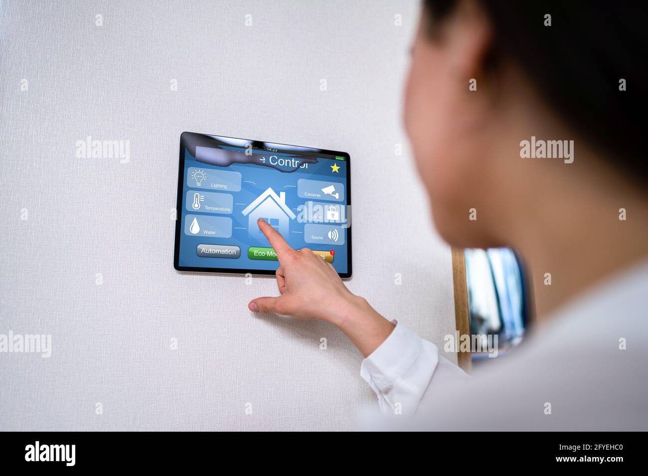 Femmes utilisant l'automatisation à domicile et le système de contrôle de caméra sur tablette Banque D'Images
