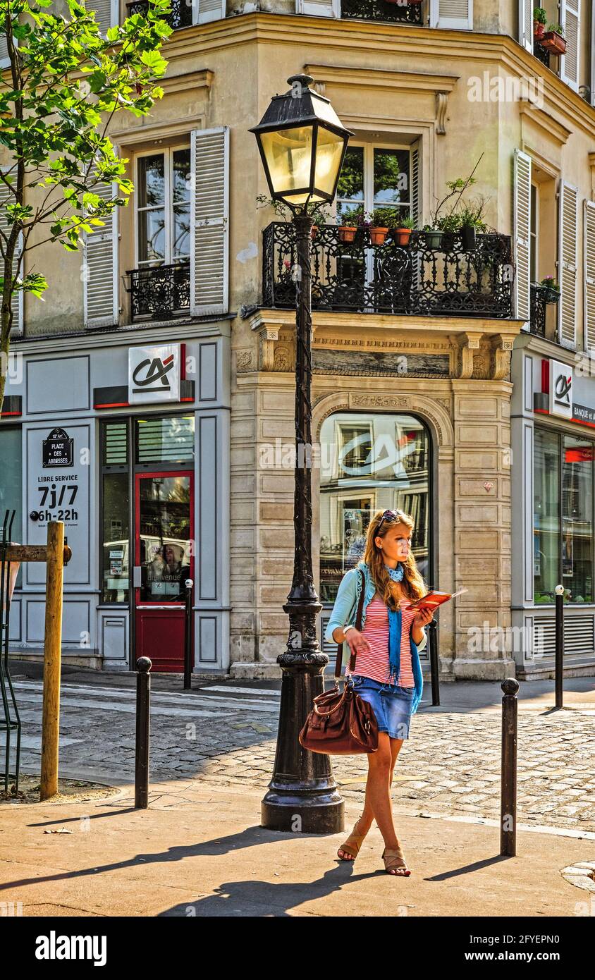 FRANCE. PARIS (75). QUARTIER DE MONTMARTRE. UNE RUSSE DÉCOUVRANT PARIS SUR UNE CARTE DE LA PLACE DES ABBESSES Banque D'Images