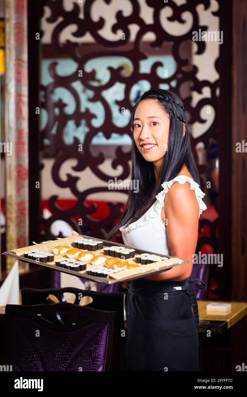 Serveuse en restaurant asiatique avec sushi Banque D'Images