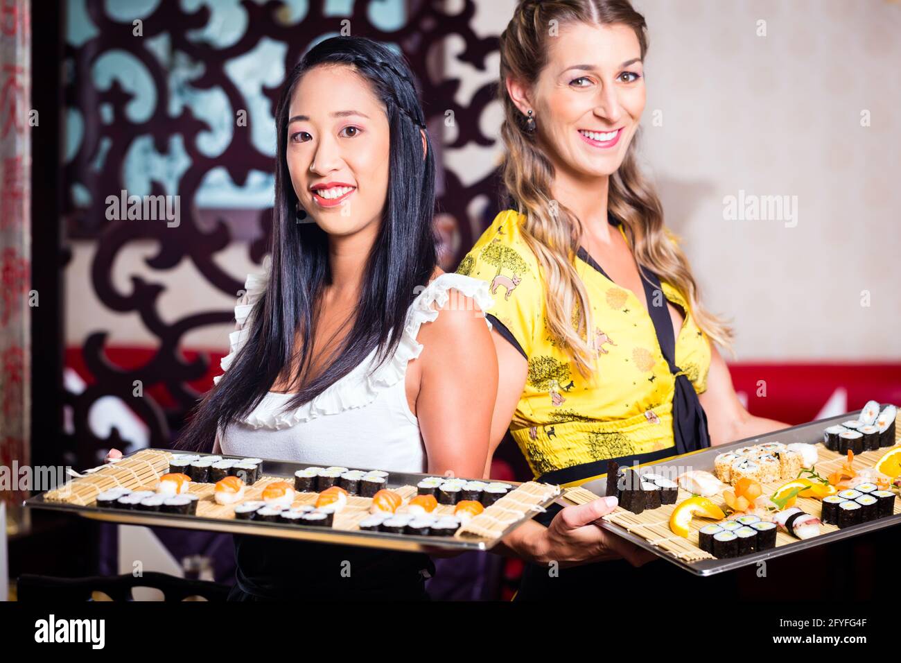 Serveuse en restaurant asiatique avec sushi Banque D'Images