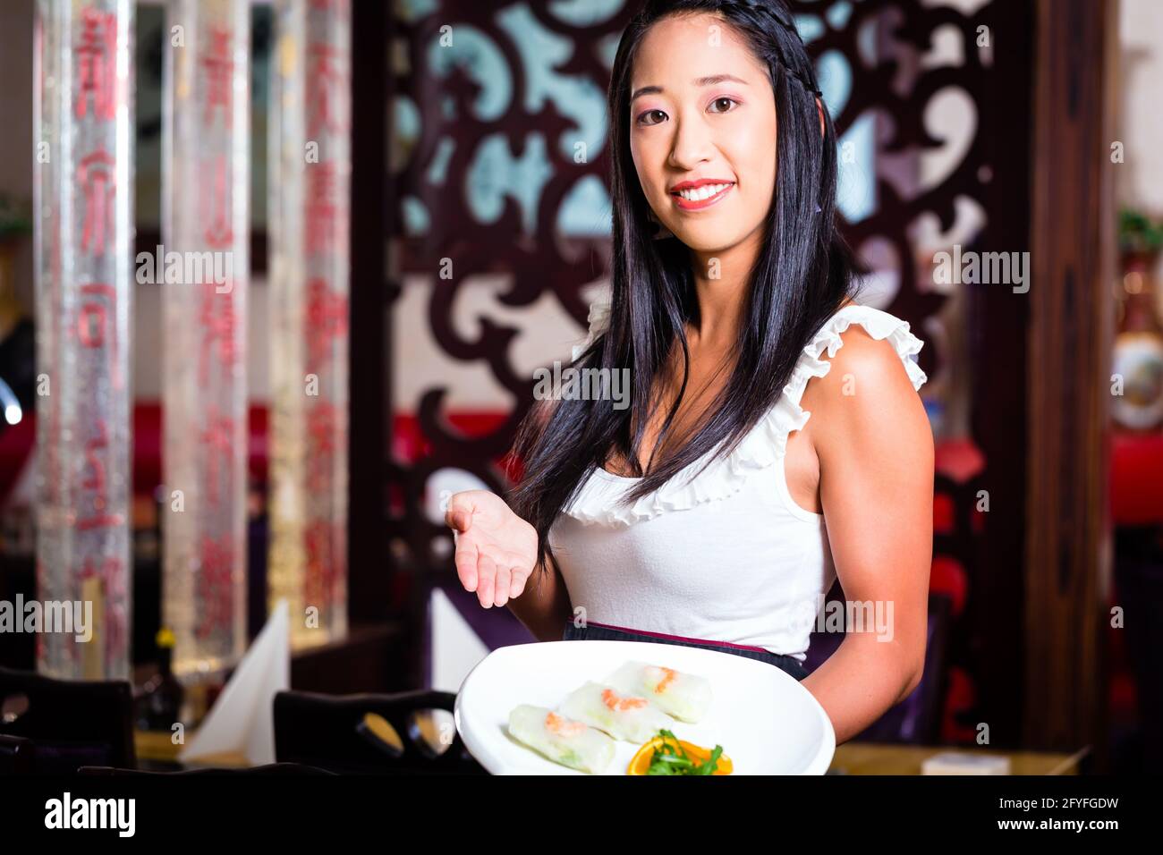 Serveuse en restaurant asiatique avec sushi Banque D'Images