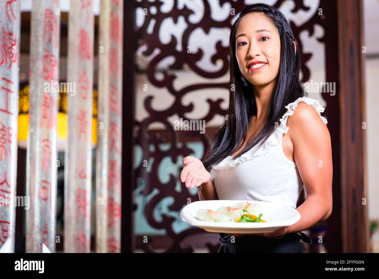 Serveuse en restaurant asiatique avec sushi Banque D'Images