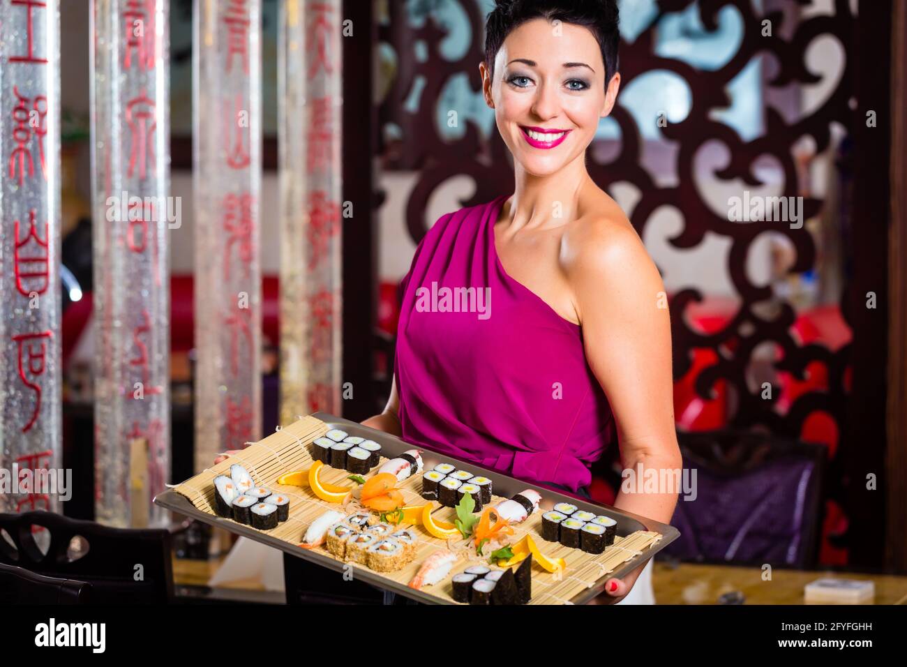 Serveuse en restaurant asiatique avec sushi Banque D'Images
