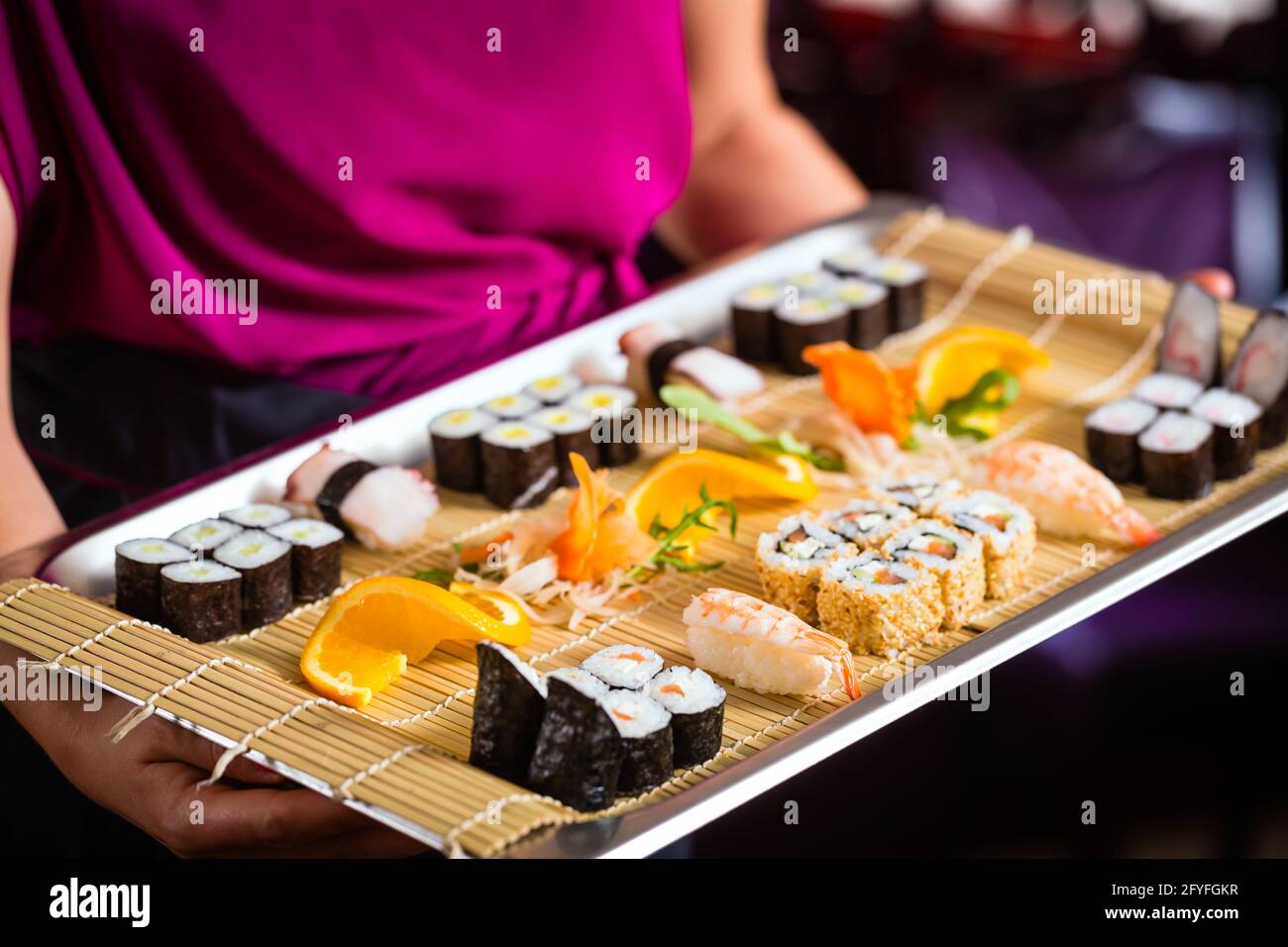 Serveuse en restaurant asiatique avec sushi Banque D'Images