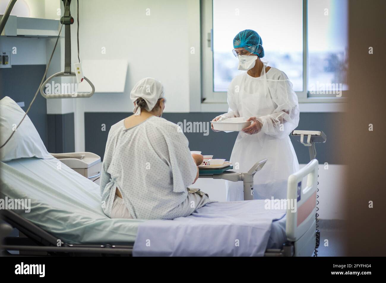 Infirmière dans la chambre d'un patient âgé, unité d'hospitalisation Covid du CHU de Limoges. Banque D'Images