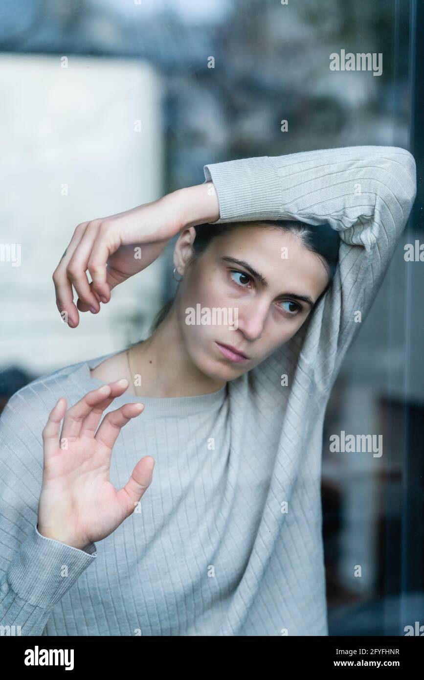 Jeune femme derrière une fenêtre. Banque D'Images