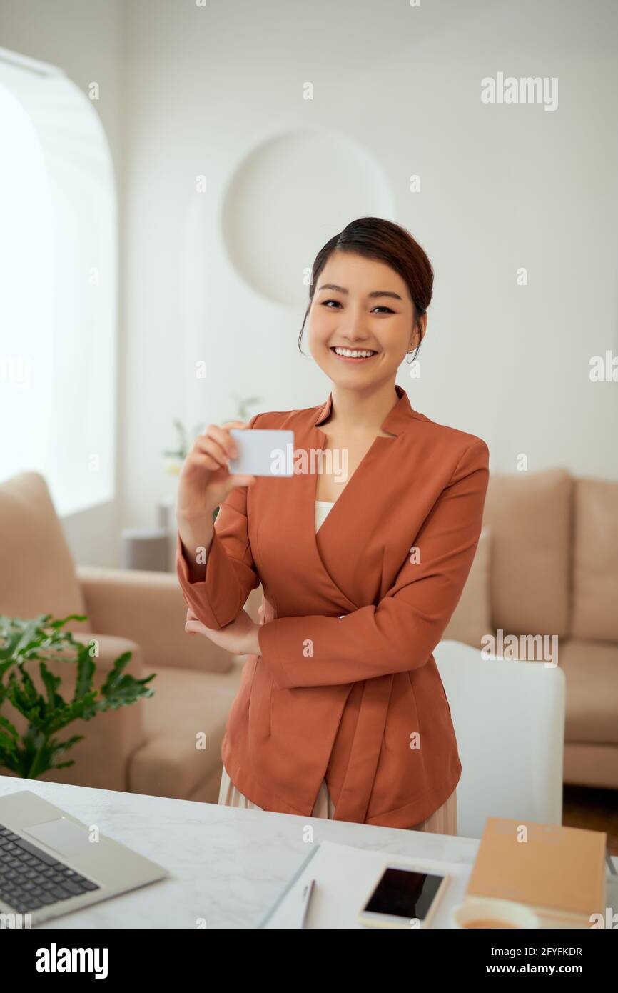 Femme d'affaires tenant et montrant une carte de visite blanche ou un nom de carte vierge entre les mains. Banque D'Images