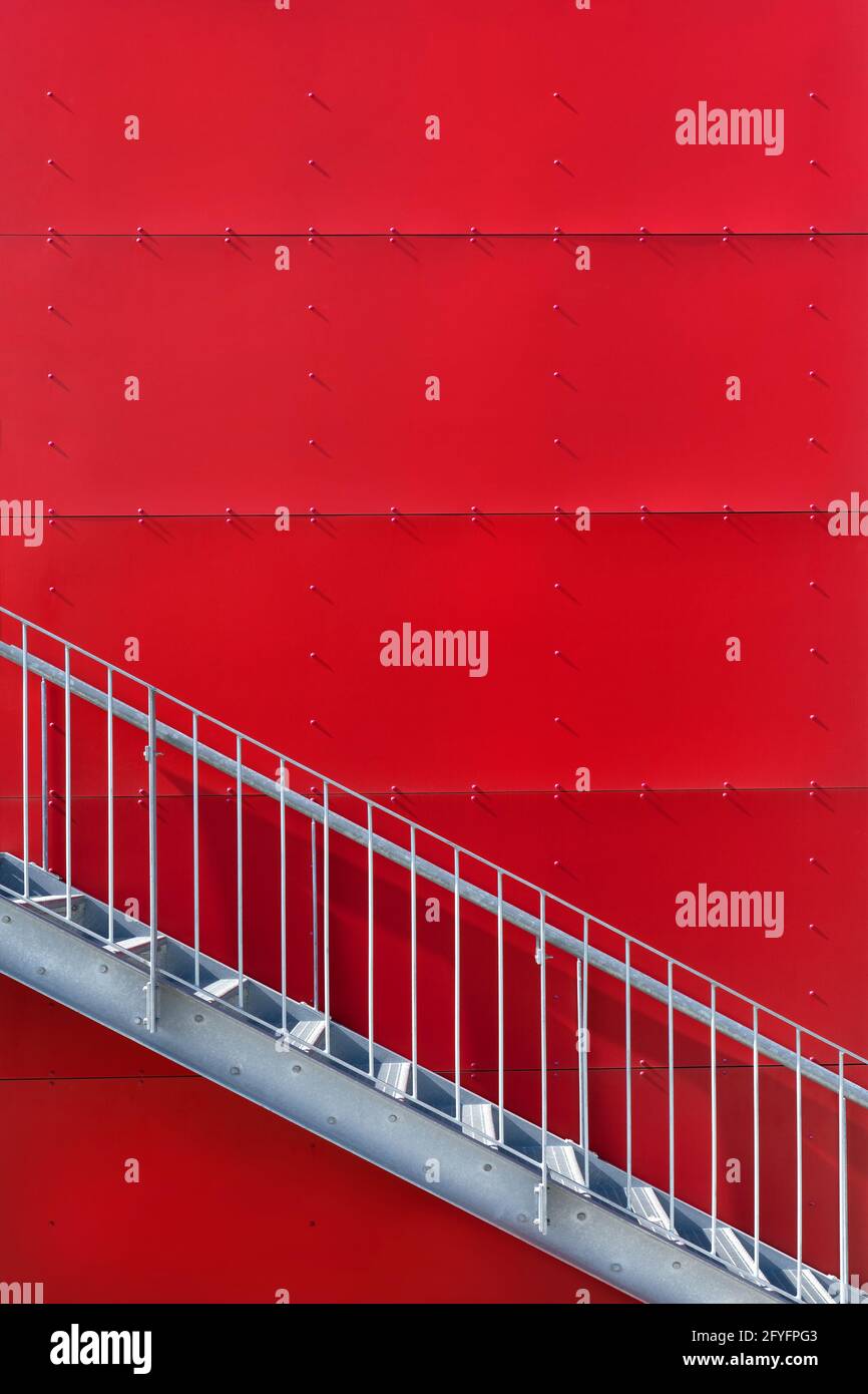 Escalier en métal à l'extérieur devant un mur rouge Banque D'Images