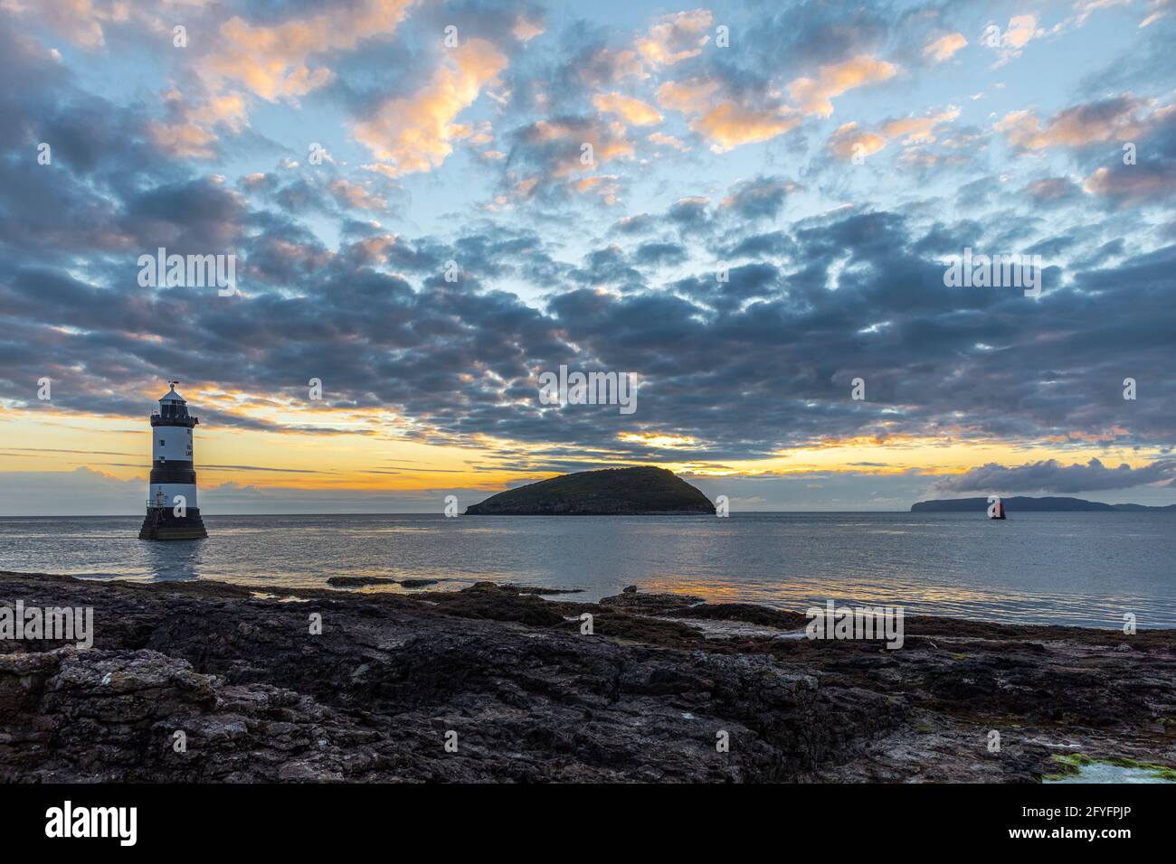 Penmon Lighthouse, Trwyn du, Puffin Island au lever du soleil depuis Penmon point, Anglesey, pays de Galles. Banque D'Images