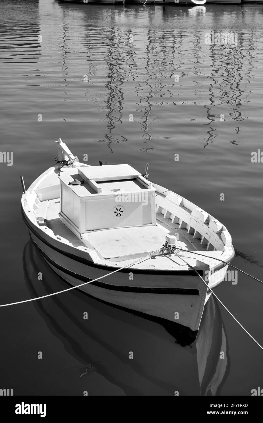 Petit bateau de pêche blanc. Photographie en noir et blanc. Héraklion, Grèce Banque D'Images