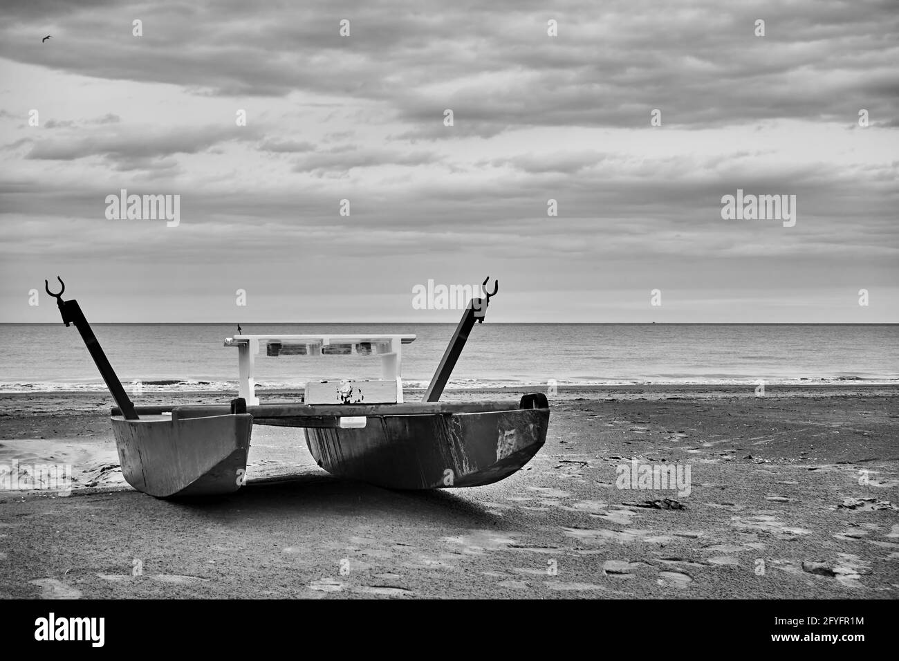 Plage déserte avec bateau de sauvetage au bord de la mer. Photographie en noir et blanc, paysage. Rimini, Italie Banque D'Images