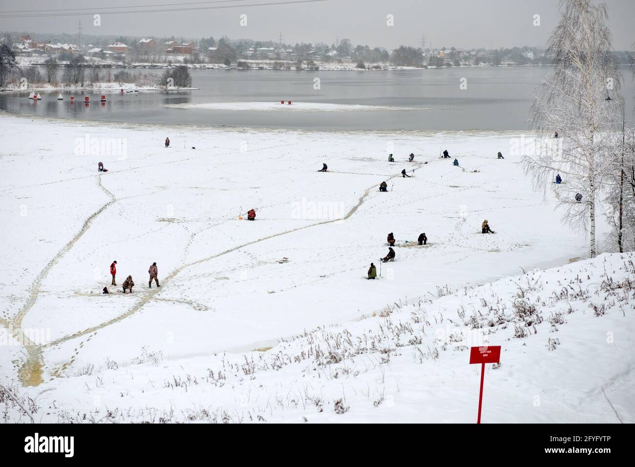 Dubna, Russie - janvier 5 2021: Pêche sur glace pêcheurs sur glace en hiver par une journée hivernale glacielle Banque D'Images