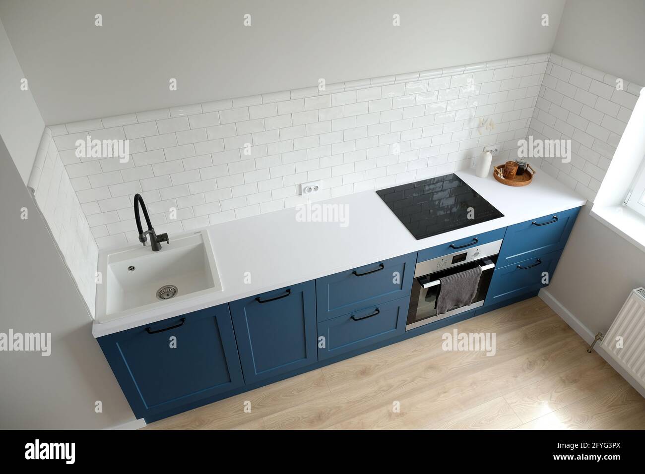 Décoration intérieure scandinave. Petite cuisine avec armoires bleues et comptoir blanc, vue sur le dessus de la cuisine nordique. Carreaux blancs sur le mur. Banque D'Images