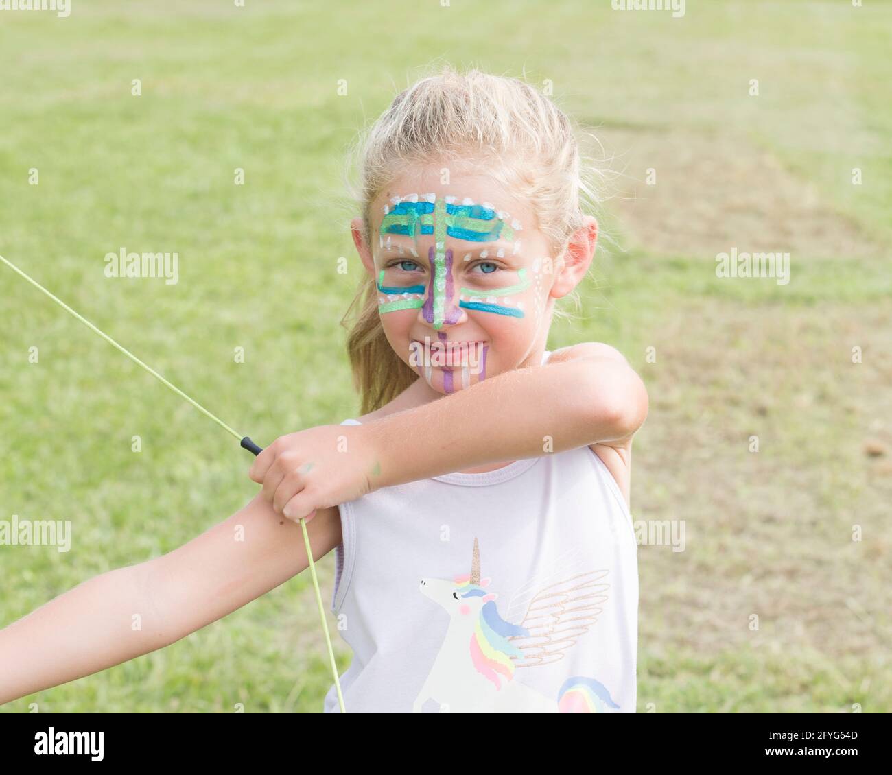 fille de 6 ans avec un arc (et une flèche). Son visage est peint comme un Indien. Banque D'Images