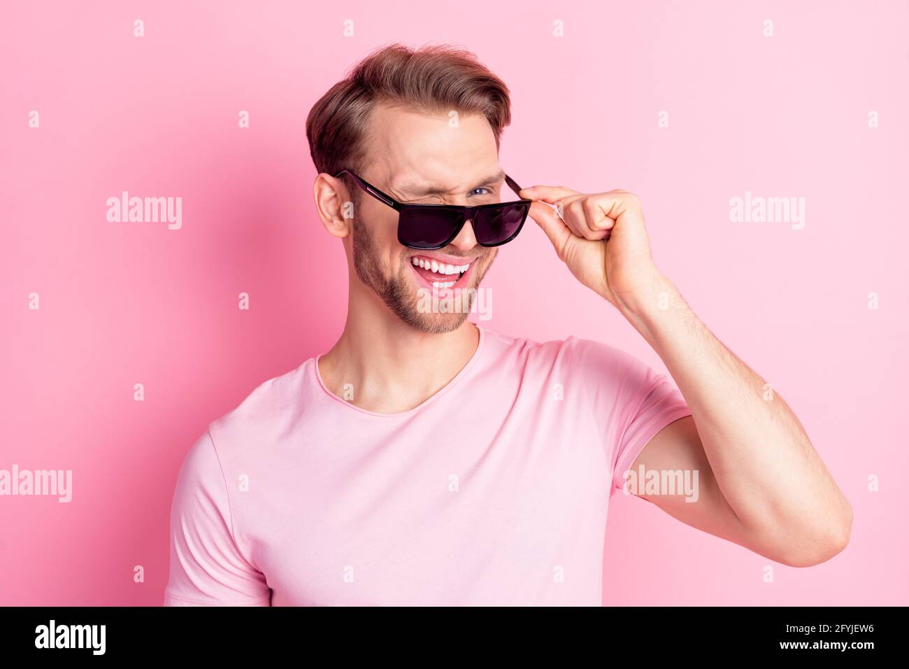 Photo de doux flirty jeune gars porte décontracté vêtements bras lunettes  sombres sourire en clin d'œil isolé couleur rose arrière-plan Photo Stock -  Alamy