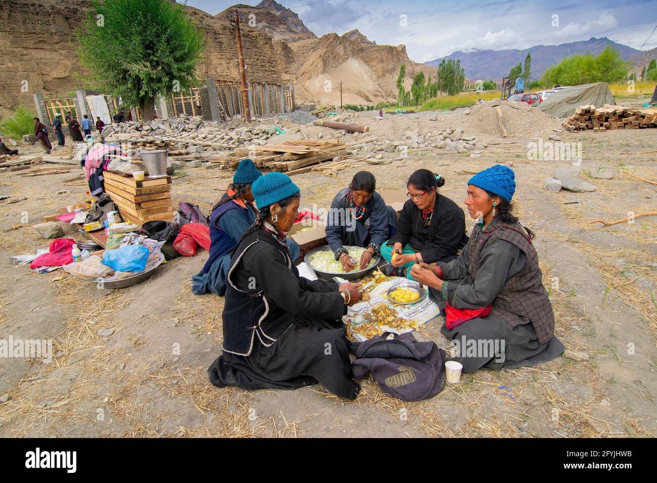 Mulbekh, Ladakh, Inde - 2 septembre 2014 : femmes tribales Ladakhi dans des robes traditionnelles coupant des légumes pour préparer la nourriture pour le festival religieux Banque D'Images