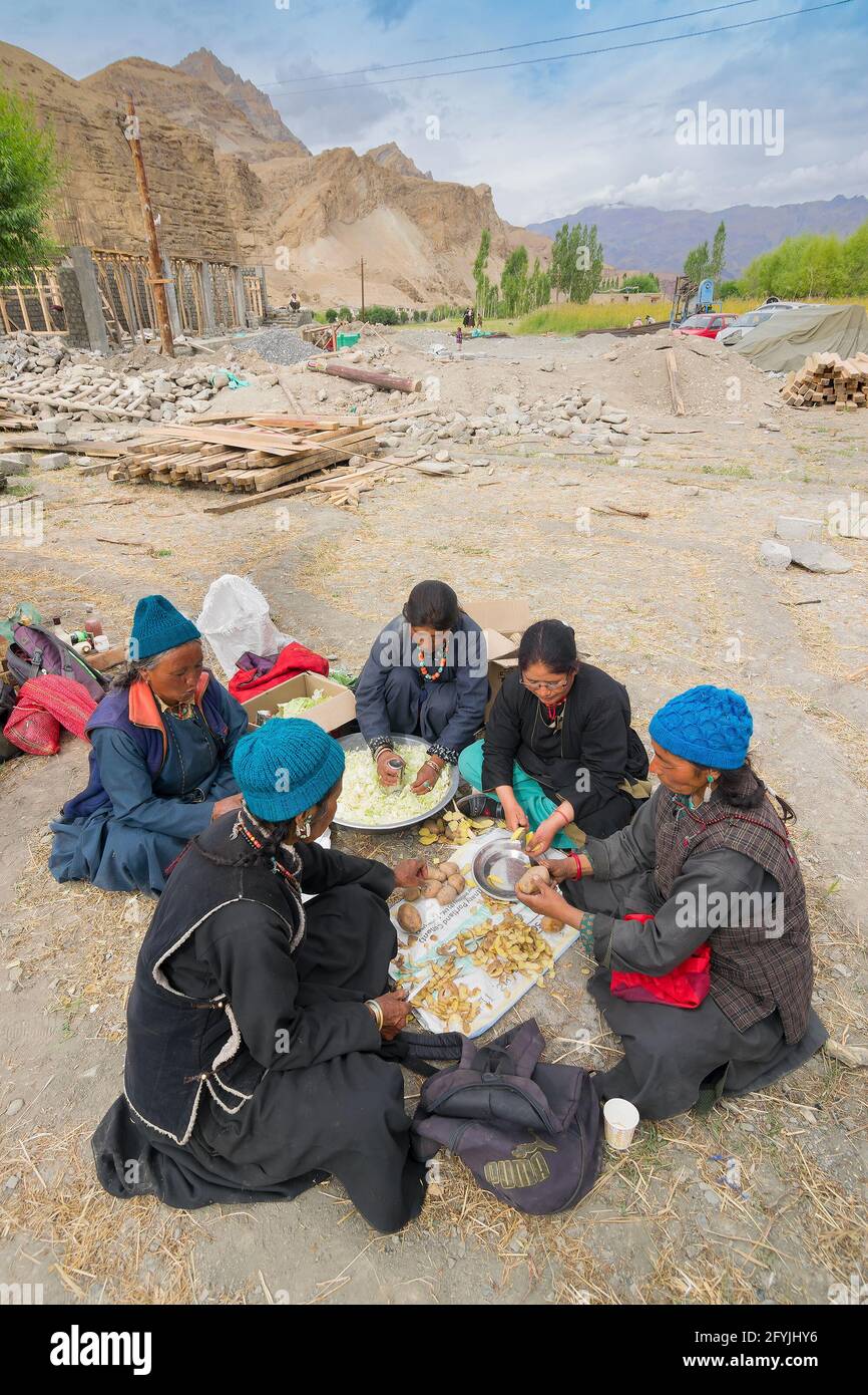 Mulbekh, Ladakh, Inde - 2 septembre 2014 : femmes tribales Ladakhi dans des robes traditionnelles coupant des légumes pour préparer la nourriture pour le festival religieux Banque D'Images