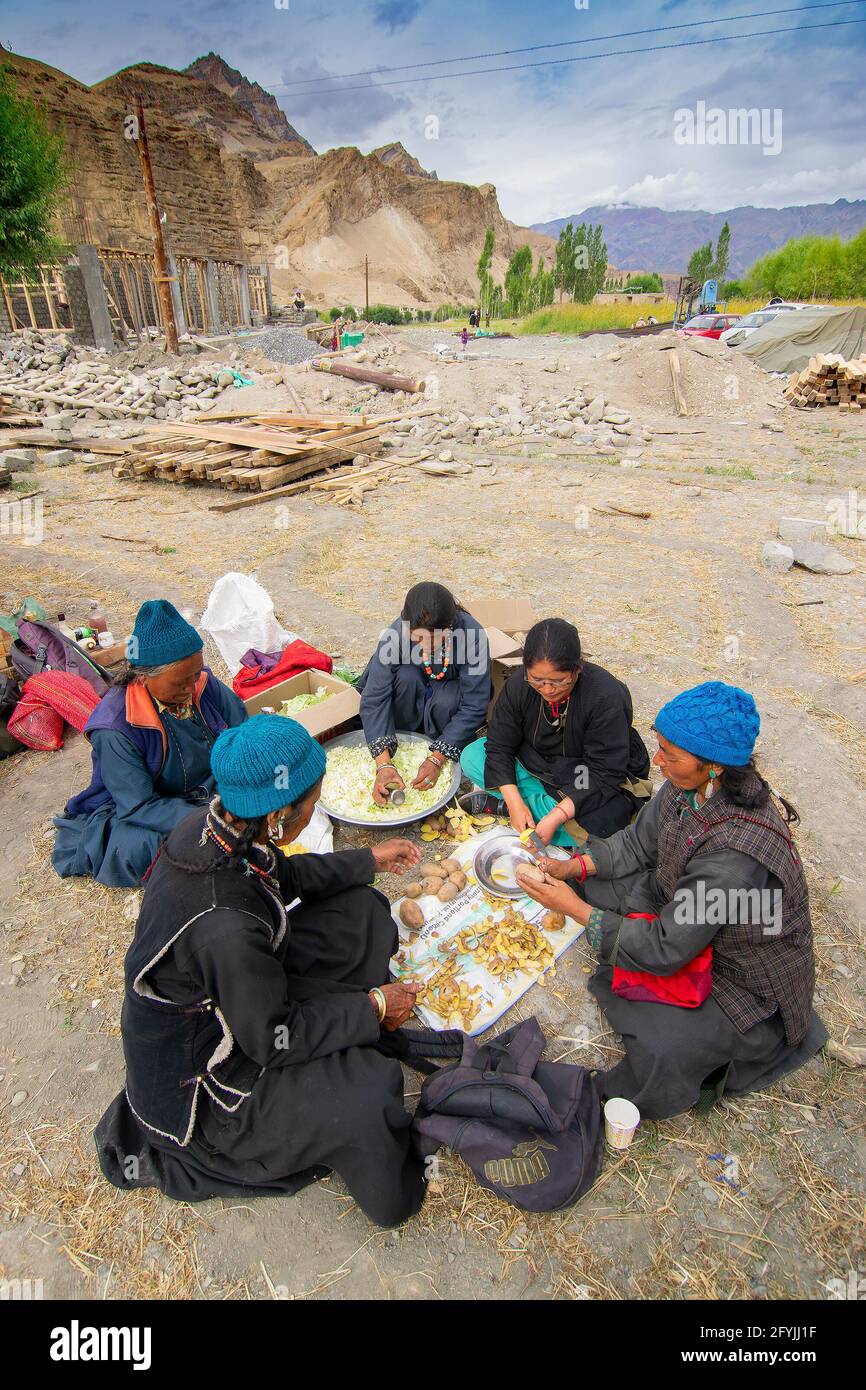 Mulbekh, Ladakh, Inde - 2 septembre 2014 : femmes tribales Ladakhi dans des robes traditionnelles coupant des légumes pour préparer la nourriture pour le festival religieux Banque D'Images