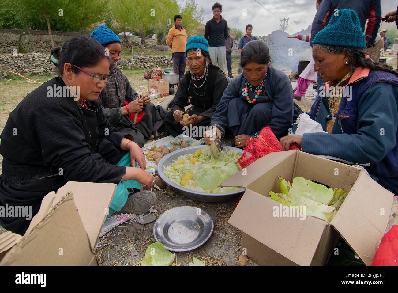 Mulbekh, Ladakh, Inde - 2 septembre 2014 : femmes tribales Ladakhi dans des robes traditionnelles coupant des légumes pour préparer la nourriture pour le festival religieux Banque D'Images
