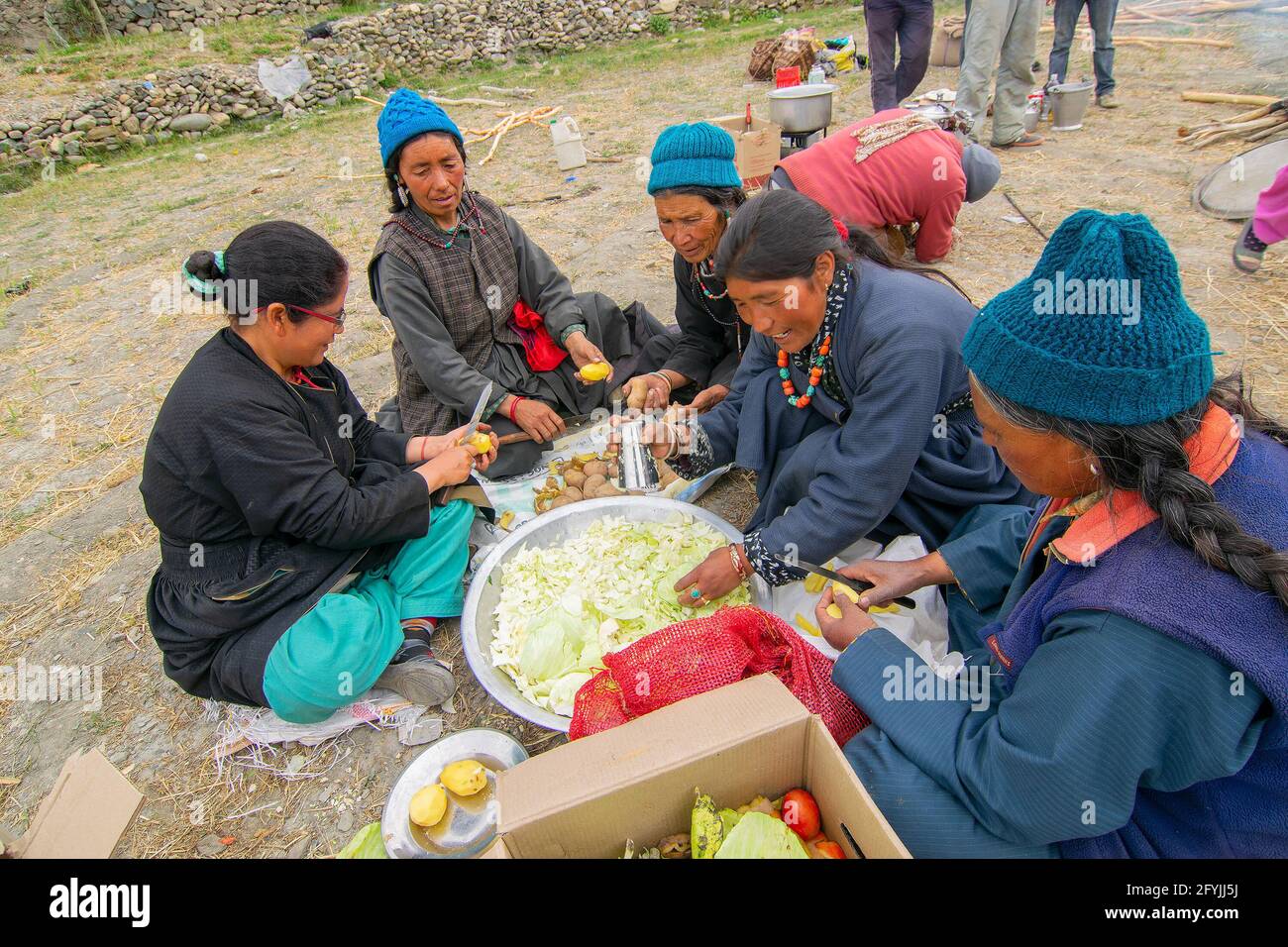 Mulbekh, Ladakh, Inde - 2 septembre 2014 : femmes tribales Ladakhi dans des robes traditionnelles coupant des légumes pour préparer la nourriture pour le festival religieux Banque D'Images