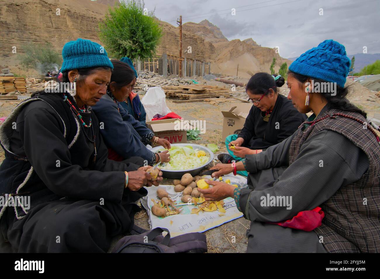 Mulbekh, Ladakh, Inde - 2 septembre 2014 : femmes tribales Ladakhi dans des robes traditionnelles coupant des légumes pour préparer la nourriture pour le festival religieux Banque D'Images