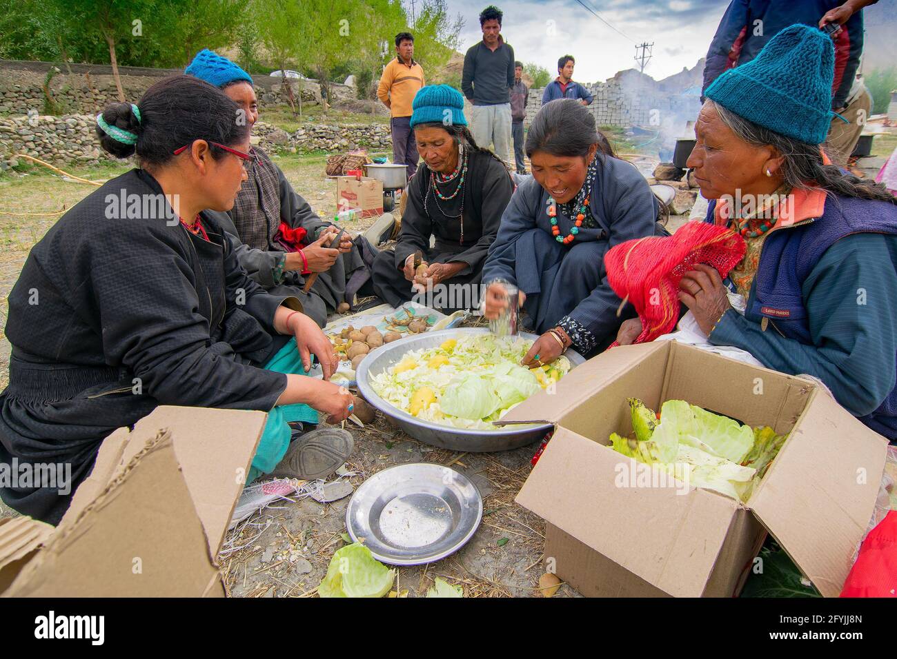 Mulbekh, Ladakh, Inde - 2 septembre 2014 : femmes tribales Ladakhi dans des robes traditionnelles coupant des légumes pour préparer la nourriture pour le festival religieux Banque D'Images