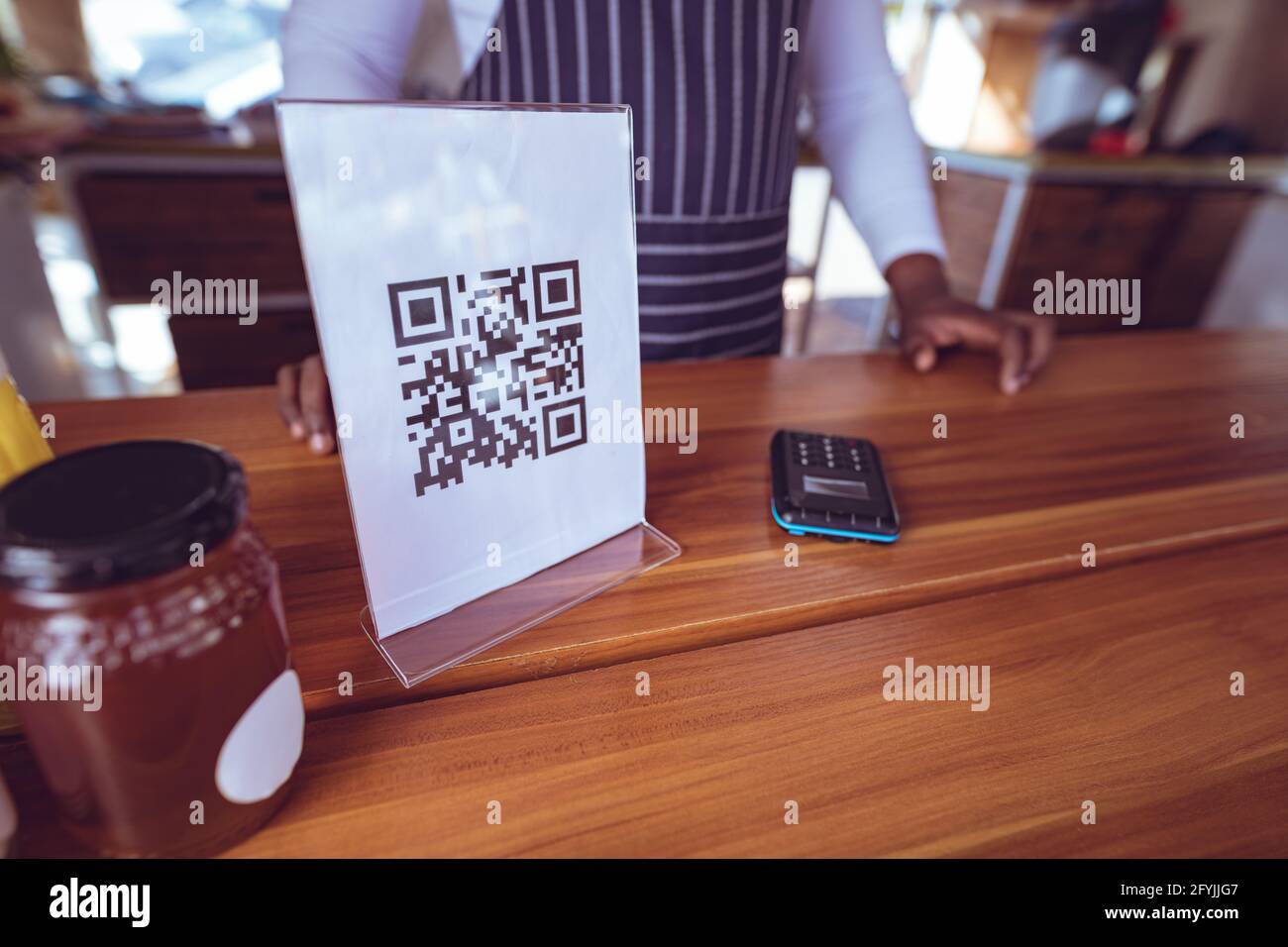 Mi-section de l'homme afro-américain en camion alimentaire avec qr menu code sur le plan de travail Banque D'Images