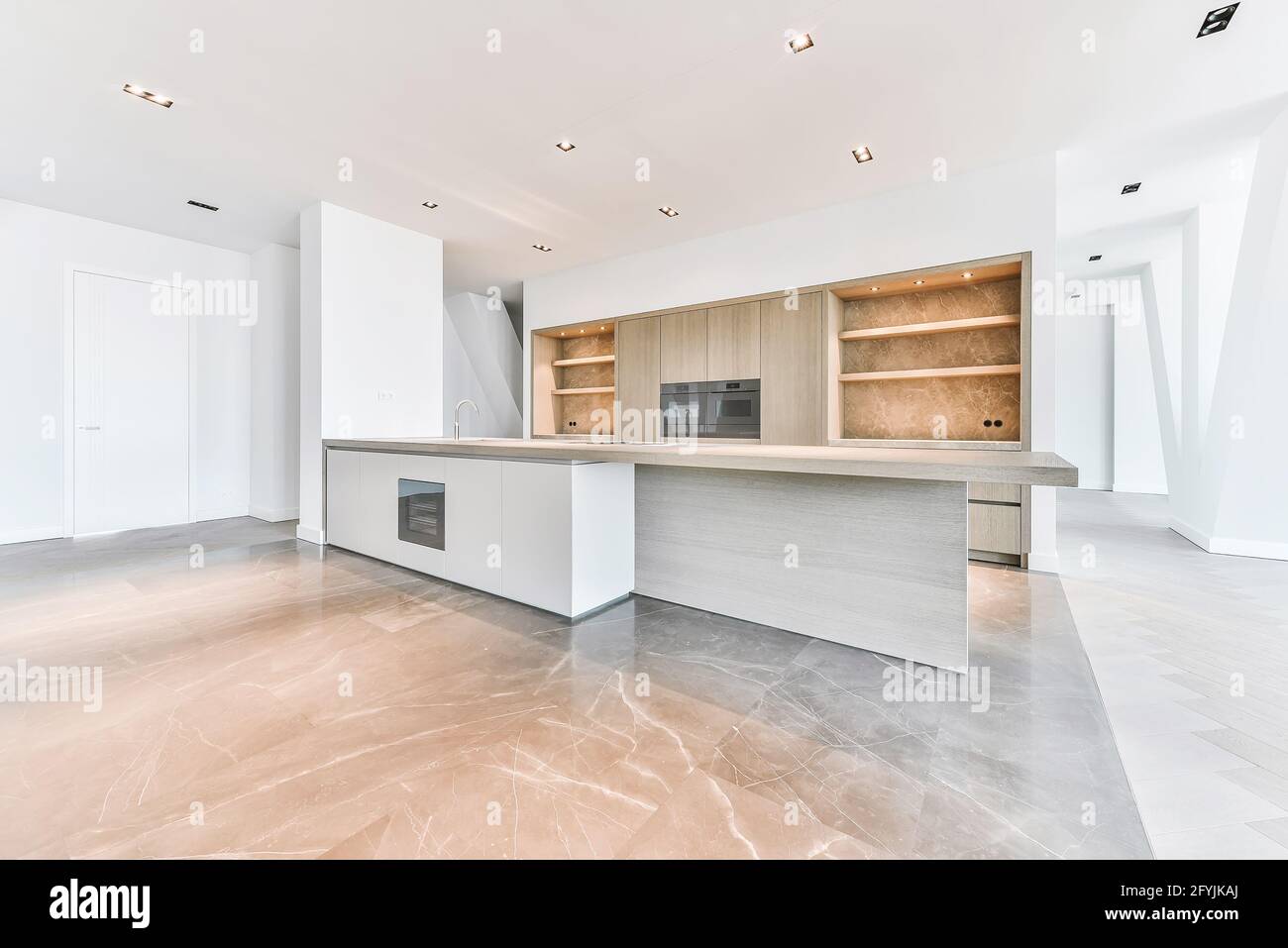 Intérieur de l'appartement de grand standing avec parquet et sol en marbre et cuisine minimaliste avec armoires en bois Banque D'Images