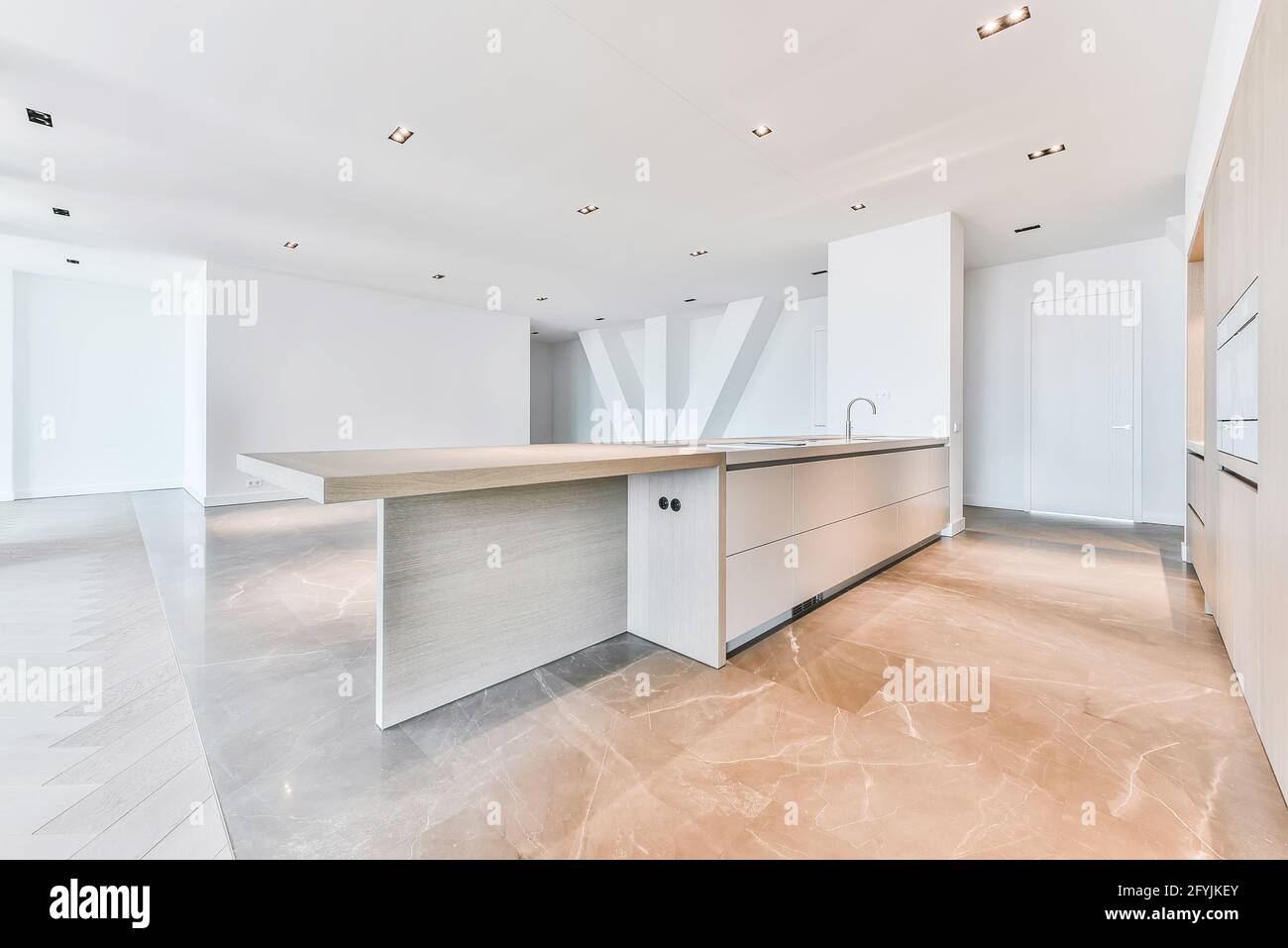 Intérieur de l'appartement de grand standing avec parquet et sol en marbre et cuisine minimaliste avec armoires en bois Banque D'Images
