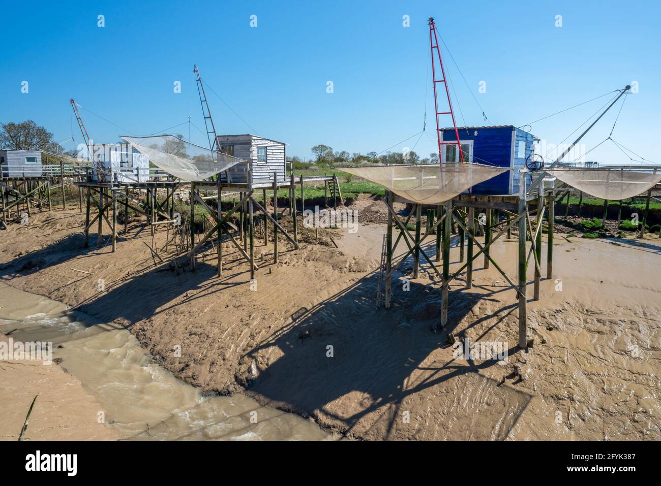 Cabanes de pêche sur pilotis au soleil dans un petit port sur l'estuaire de la Gironde, Charente Maritime, France côte ouest de l'Atlantique Banque D'Images