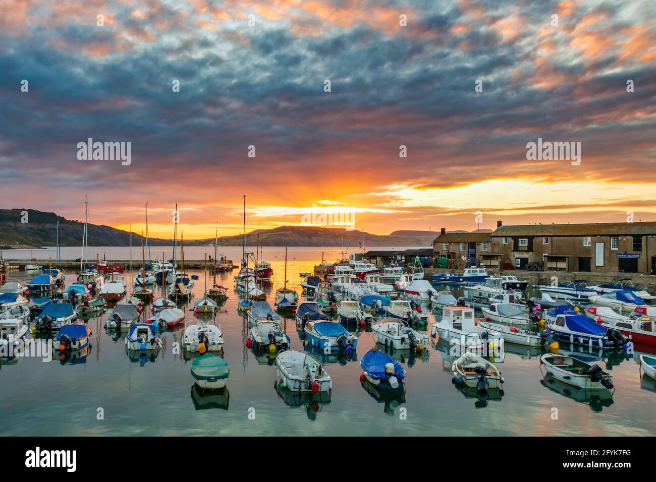 Un lever de soleil spectaculaire au port de Lyme Regis à Dorset. Banque D'Images