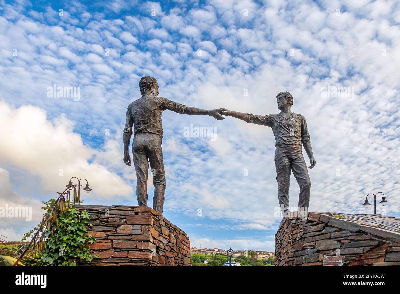 La sculpture « mains à travers la ligne de partage » à Derry, en Irlande du Nord. La statue a été créée par Maurice Harron et érigée en 1992. Banque D'Images