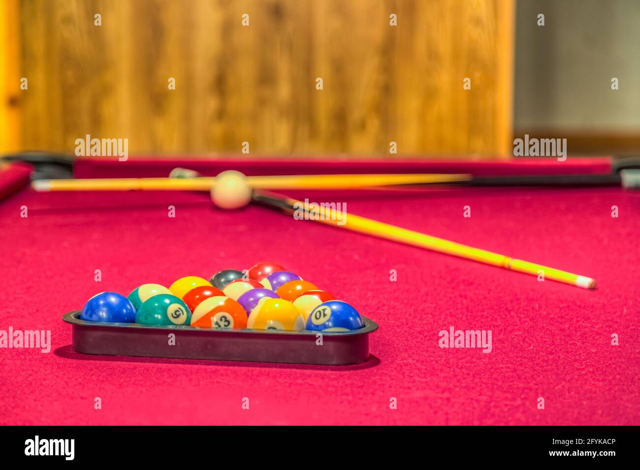 Table de billard rouge pastel avec boules dans un rack Banque D'Images