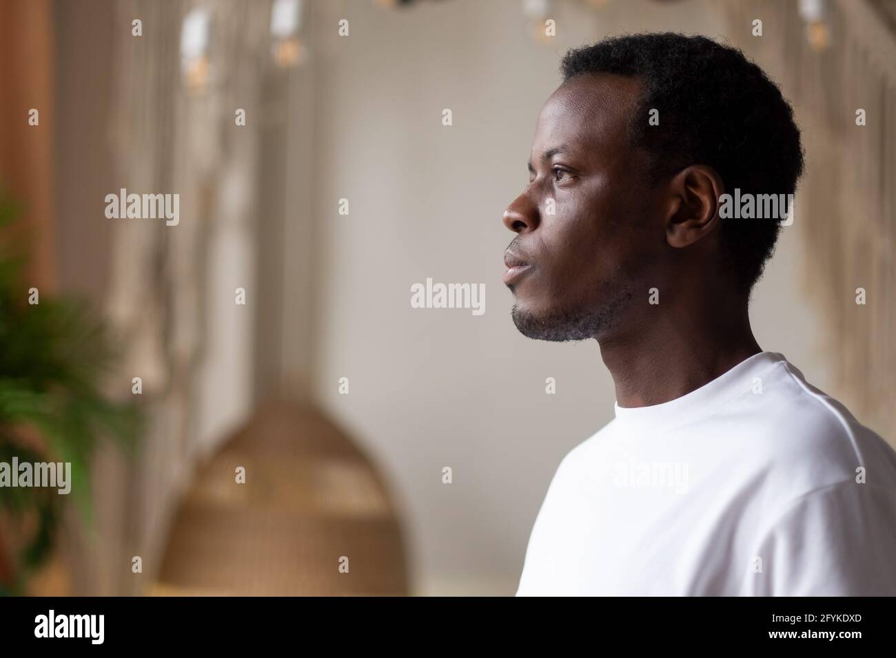 Homme africain debout seul à la maison pour planifier le jour futur Banque D'Images