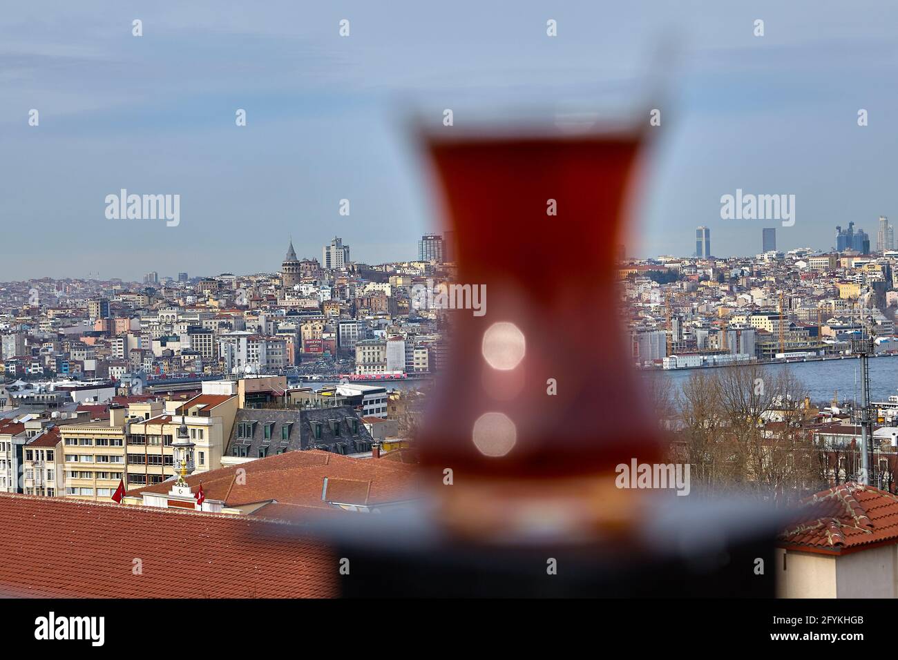 Armudu au thé noir turc se trouve sur le pilier de la clôture de toit en face du paysage urbain d'Istanbul, en se concentrant sur l'arrière-plan. Banque D'Images