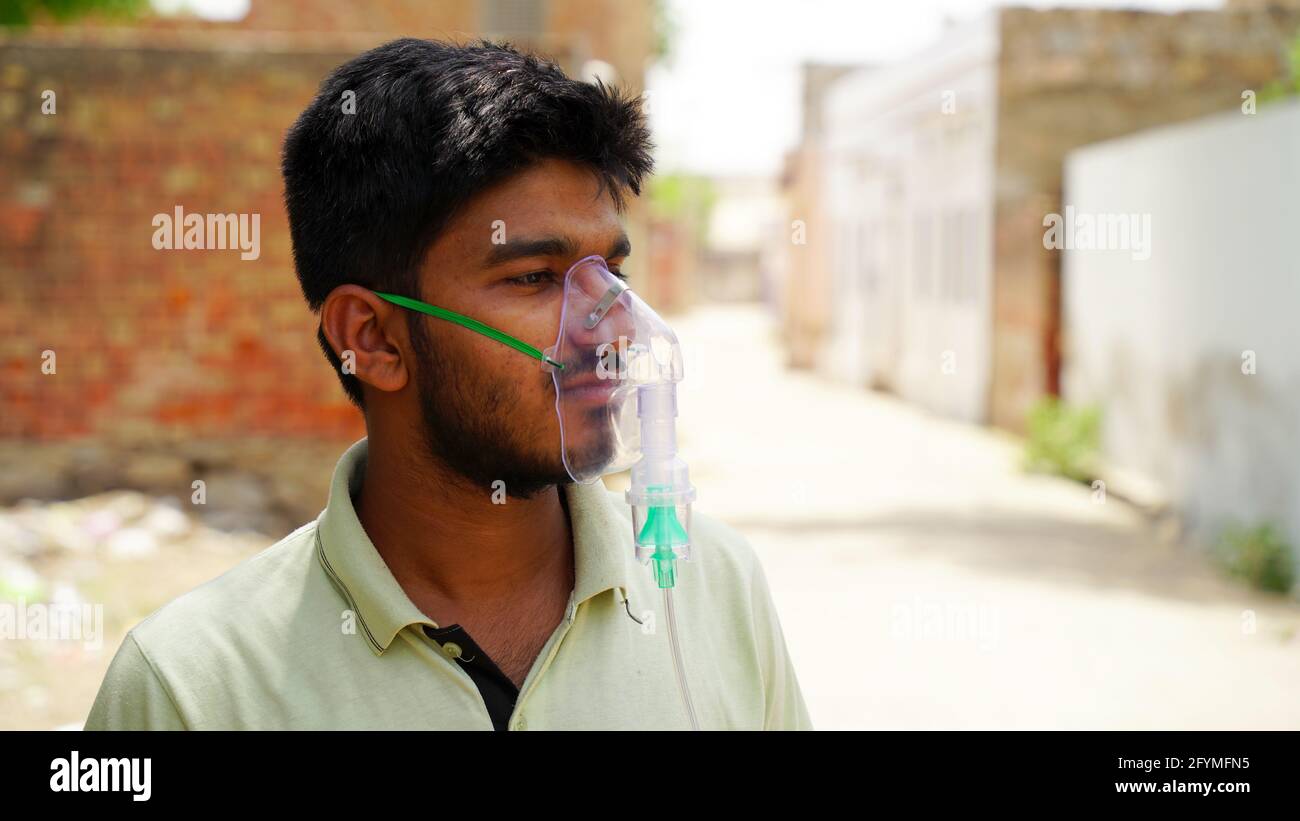 Jaipur, Inde - Mai 21: Gros plan malade Yong garçon avec masque d'oxygène du visage avec liquide flux d'oxygène à l'extérieur de l'hôpital. Garçon infecté par la maladie de Covid 19. Banque D'Images