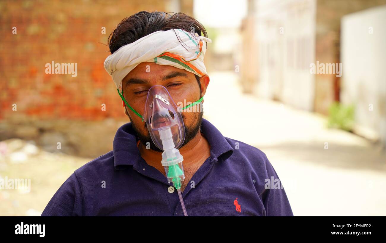 Jaipur, Inde - Mai 21: Gros plan malade Yong garçon avec masque d'oxygène du visage avec liquide flux d'oxygène à l'extérieur de l'hôpital. Garçon infecté par la maladie de Covid 19. Banque D'Images