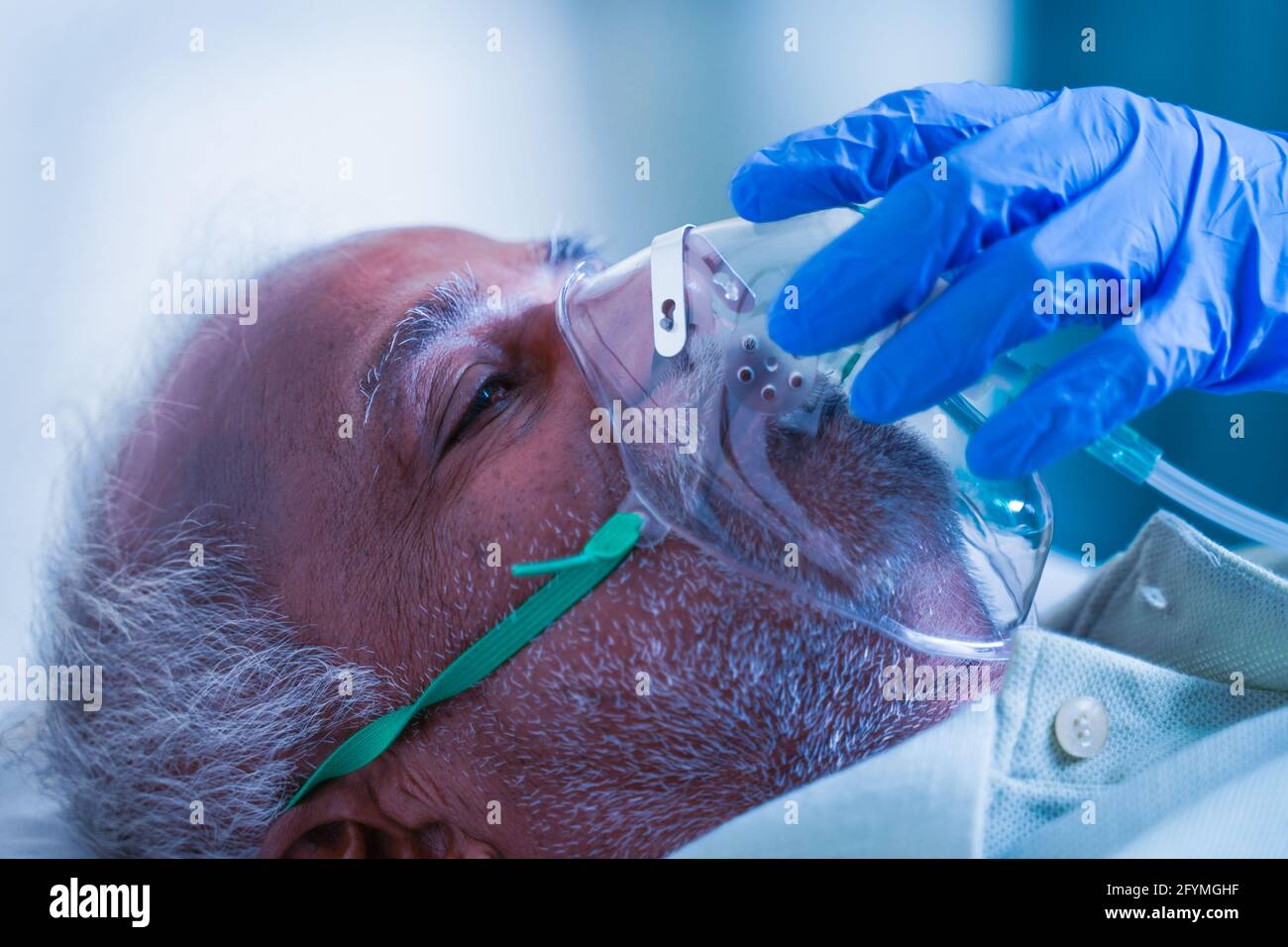 Gros plan, le docteur aide en ajustant le masque d'oxygène de ventilation à la difficulté infectée de covid dans la respiration ou l'essoufflement au patient à l'hôpital Banque D'Images