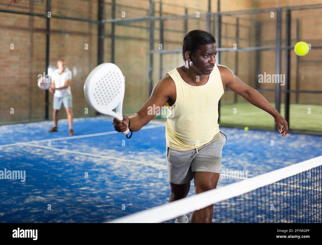 Portrait d'un joueur de paddle-tennis afro-américain concentré qui se  prépare à frapper l'avant-main pour retourner le ballon sur un court  intérieur Photo Stock - Alamy