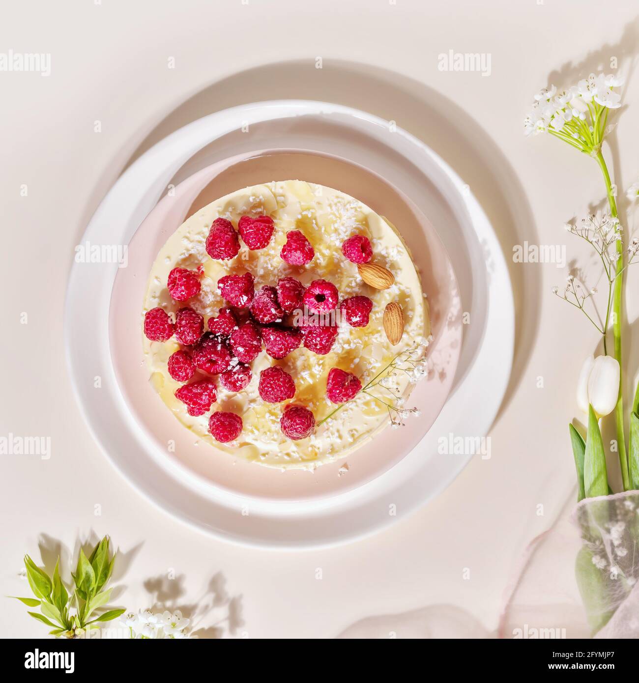 Gâteau maison aux framboises et aux amandes sur une assiette blanche sur fond rose. Les pâtisseries sucrées à la farine d'amande sont sans gluten, peu de glucides. Régime de céto Banque D'Images