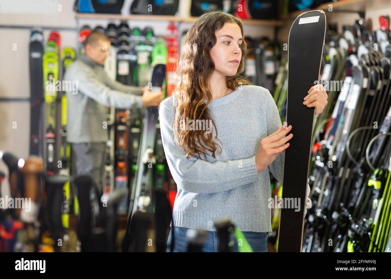 Un homme et une femme choisissent de nouveaux modèles de skis dans le magasin d'équipement de ski Banque D'Images